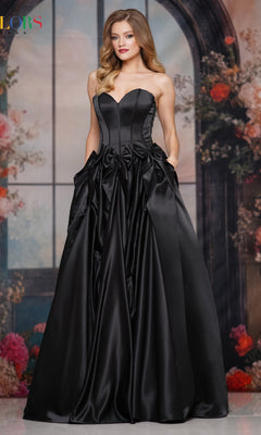 A woman in the Bow-Front Long Prom Ball Gown (Colors Dress 3739) with a fitted bodice and full skirt, poses before flowers and an arched window, embodying timeless Colors Dress elegance.