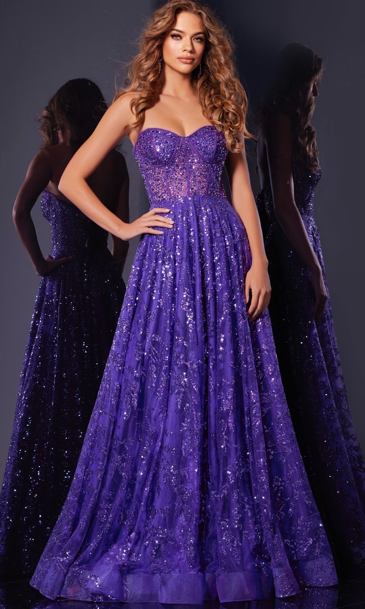 A woman in the Long Prom Dress: Jovani 37413, featuring a strapless sequin design and corset bodice, stands against a dark background with her reflection elegantly visible behind her.