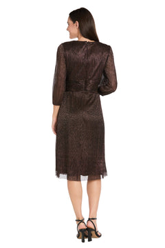 A woman faces away, modeling the R&M Richards 3741 Metallic Knee-Length Party Dress with shimmery brown fabric, long sleeves, and black heeled sandals against a white background.