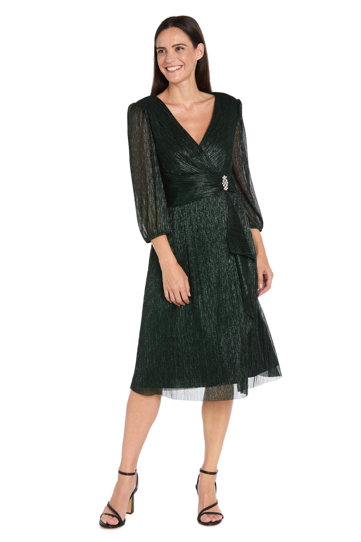 Woman wearing the R&M Richards 3741 Metallic Knee-Length Party Dress, featuring long sheer sleeves and black strappy heels—an ideal semi-formal outfit for your next event.