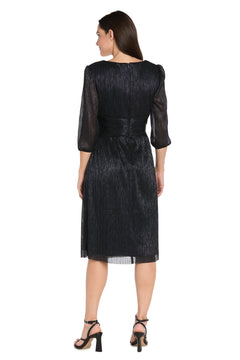 A woman faces away, wearing the R&M Richards 3741 Metallic Knee-Length Party Dress with three-quarter sleeves and shimmery black fabric, paired with black heeled sandals.