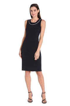 A woman stands against a white background wearing the Petite Two-Piece Party Dress: R&M Richards 3747P in navy blue, styled with black strappy heels.