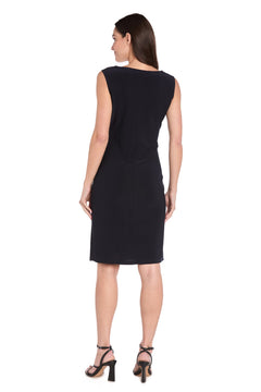 A woman faces away, highlighting the R&M Richards 3747P petite two-piece party dress—sleeveless, black, knee-length—paired with black high-heeled sandals against a white backdrop.