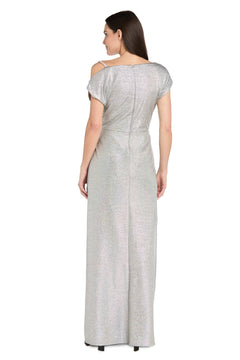 A woman faces away, wearing the R&M Richards 3758P Petite Silver Formal Dress—short-sleeved, floor-length with shimmering fabric and back seam detail—for a stunning formal evening look.