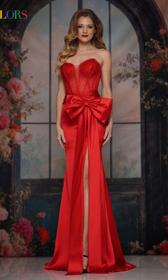 A woman poses before a floral backdrop in the Long Prom Dress: Colors Dress 3769, a strapless gown with a satin skirt, large waist bow, and thigh-high slit.
