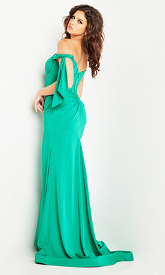 Woman wearing the Jovani Off-the-Shoulder Long Prom Dress 38197 in green, featuring bow sleeve details and a corset-style bodice, posed against a plain light background.