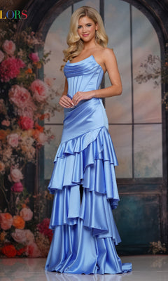 A woman in the Strapless Long Tiered Prom Gown (Colors Dress 3823) in cornflower stands before a floral, arched window backdrop.