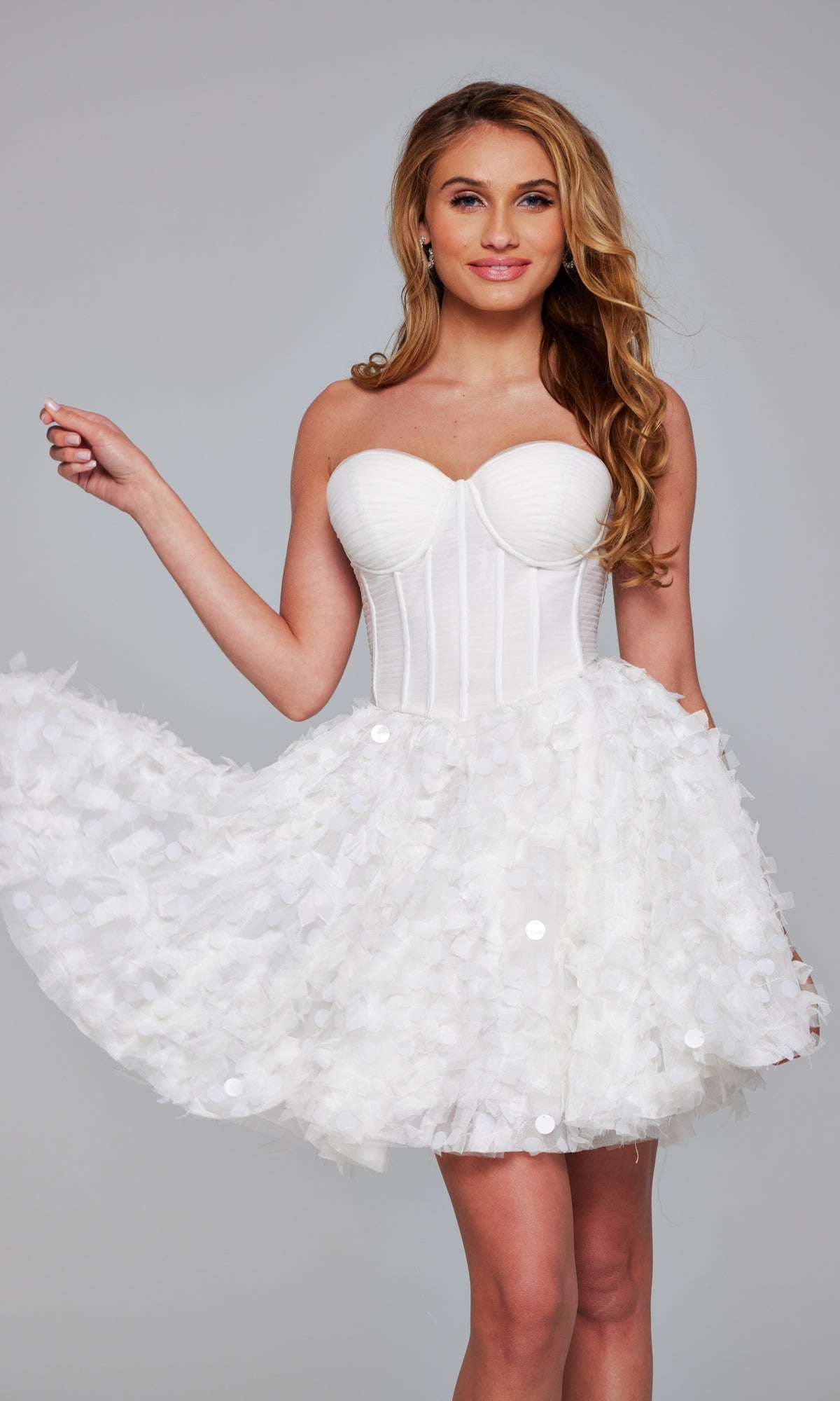 Woman models the Jovani Strapless Short White Hoco Dress 38248, featuring a fitted bodice and textured flared skirt—an elegant choice for homecoming, shown against a simple gray background.