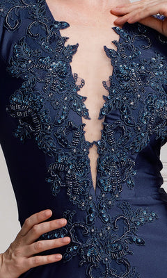 Close-up of a person wearing Long-Sleeve Plunging V-Neck Long Formal Dress 382 in navy blue, featuring intricate beaded embroidery and a deep V neckline. Their hand is resting on their hip.