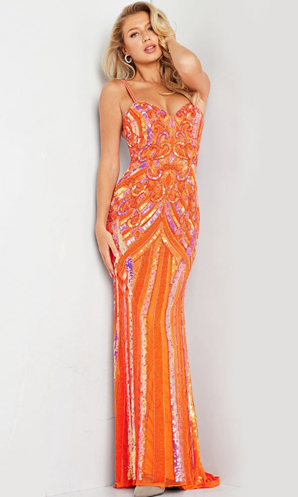A woman models the Jovani Long Sequin-Print Prom Dress 38300, a fitted, floor-length orange gown with thin straps and a patterned sequin-print design, standing against a plain background.