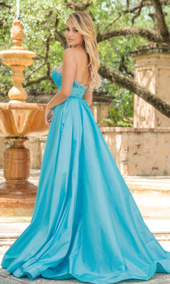 A woman in the Long Formal Dress 38337 by Ava Presley, a strapless light blue A-line gown, stands outdoors near a stone fountain with trees and sunlight in the background.