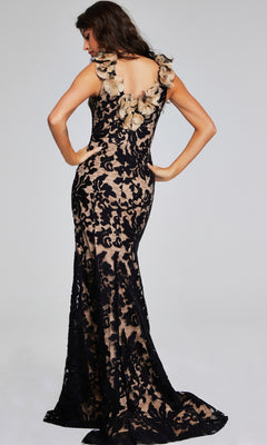A woman poses in the Jovani 38497, a long black & nude formal dress with a fit-and-flare silhouette, lace overlay, beige lining, 3D flower neckline accents, and an open back.