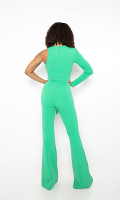 A person stands with their back to the camera, wearing the Ava Presley Long Formal Jumpsuit 38554 in bright green, featuring a round neckline and one long sleeve, set against a plain white background.