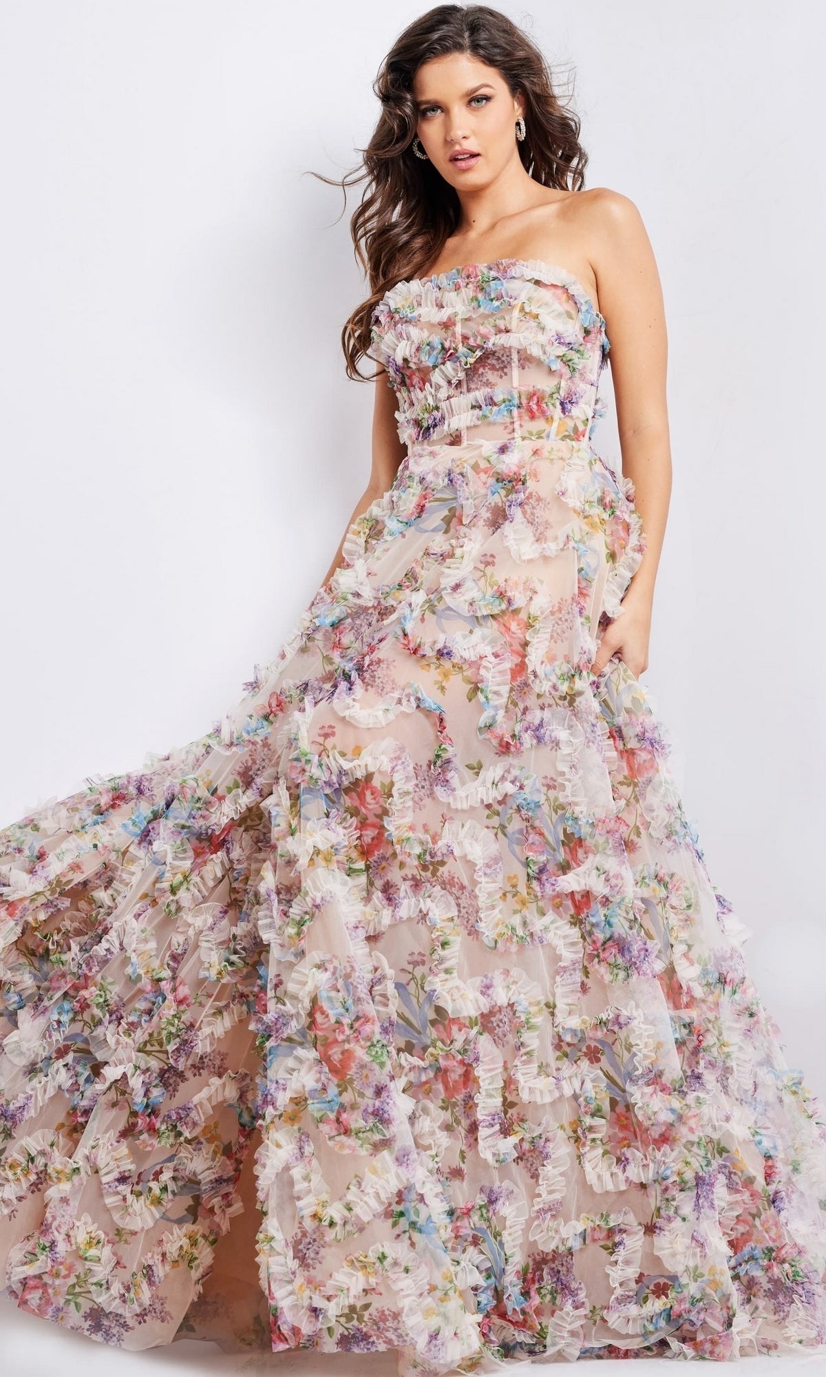 A woman wears the Jovani Strapless Long Print Prom Dress 38650, featuring a sheer nude base adorned with multicolored 3D floral appliqués for an enchanting floral look.