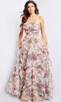 A woman in the Jovani Strapless Long Print Prom Dress 38650, featuring a sheer overlay and colorful 3D floral appliqués, stands against a plain background.