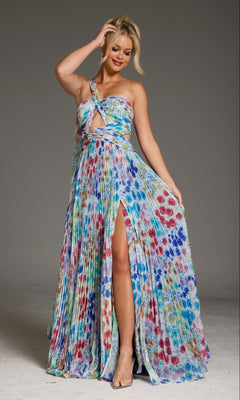 A woman in the Jovani 38689 long prom dress in print, featuring a colorful pleated A-line shape, one-shoulder design, front cutout, and thigh-high slit, stands against a plain background holding part of the skirt.