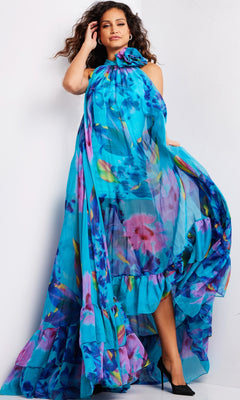 A woman poses in the Long Prom Dress 38721 by Jovani, a bright blue chiffon formal gown with a high neckline, ruffled hem, and sheer fabric, paired with black heels against a plain white background.