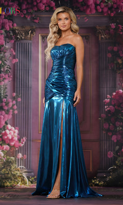 A woman wears the Colors Dress 3873, a metallic blue strapless long prom dress with a ruched bodice and thigh-high slit, standing before a floral and column backdrop.