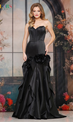 A woman wears the Long Prom Dress: Colors Dress 3880, a strapless gown with 3D rosette appliques at the hips, standing before a floral and arch backdrop.