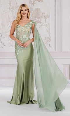 A woman stands indoors wearing the One-Shoulder Long Formal Dress with Cape 388, a light green formal gown featuring floral embroidery, a corset-style bodice, and a matching sheer cape draped over one shoulder.