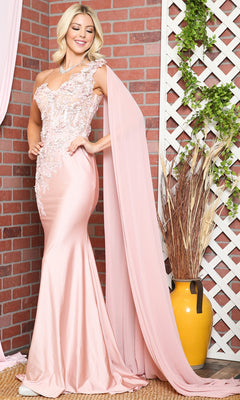 Woman in front of a brick wall wearing the One-Shoulder Long Formal Dress with Cape 388 in pale pink, featuring floral detailing, a corset-style bodice, and a flowing cape.