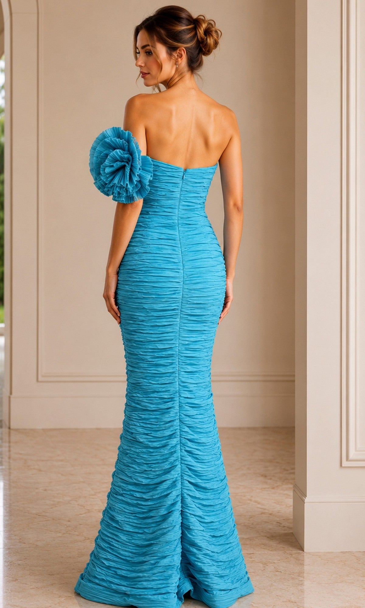 A woman wearing the Jovani 38947 long formal dress—a fitted, textured turquoise gown featuring a large ruffled embellishment on one shoulder and ruched detailing—stands indoors with her back to the camera.
