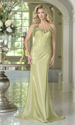 Woman wearing the Strapless Long Rosette Prom Gown (Colors Dress 3895) in sage, featuring a sweetheart neckline and floral bodice, stands in an elegant, bright room with ornate decor and large windows.