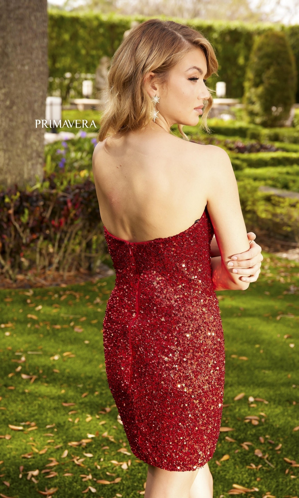 A woman shines with confidence in the Strapless Sweetheart Sequin Homecoming Dress 3899, its sparkling red sequins glimmering under the party lights.
