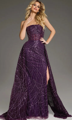 A woman poses against a gray background wearing the Jovani 39029 long formal dress in plum—a strapless, floor-length gown adorned with glittering geometric patterns and a thigh-high slit.
