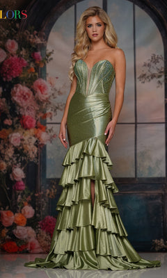 A woman stands before a floral backdrop wearing the Colors Dress 3925, a long prom dress featuring rhinestone embellishments, tiered ruffles, sparkly accents, and a fitted strapless design.