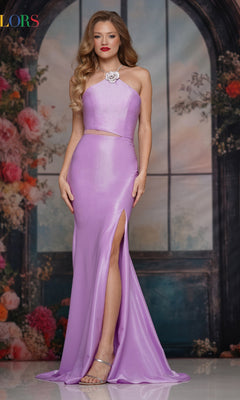 A woman in the Cut-Out Sleek Long Prom Dress: Colors Dress 3926, a shiny lilac gown with a corset-style bodice and high slit, stands before a floral and arched window backdrop.