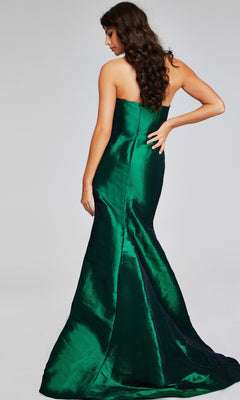 A woman with long curly hair models the Jovani 39368, a strapless, floor-length emerald green formal dress with a fitted bodice and flared skirt, standing with her back to the camera.