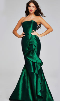 A woman stands against a plain background wearing the Jovani 39368, a long formal strapless mermaid gown in emerald green with front ruffle detail.