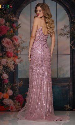 A woman in the Colors Dress 3940, a long prom dress with a fitted corset bodice and pink sequins, stands before a floral arched window backdrop, facing slightly backward and looking over her shoulder.
