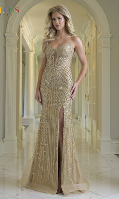 A woman stands in a hallway wearing the Colors Dress 3940, a form-fitting gold long prom dress with a corset bodice, intricate beadwork, hot-stone embellishments, and two high slits for added elegance.