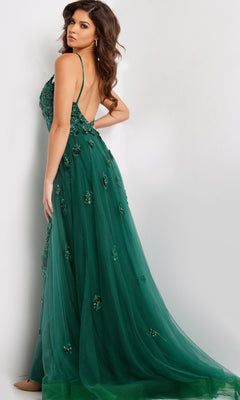 A woman models the Long Prom Dress 39434 by Jovani—a dark green, beaded formal gown featuring thin straps and an open back—against a light background, looking over her shoulder.
