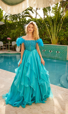 A woman stands by a pool, surrounded by greenery and outdoor furniture, wearing the Ava Presley 39553 Feather Long Prom Ball Gown in turquoise with feathered off-the-shoulder sleeves.
