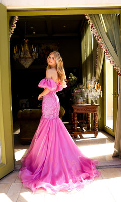 A woman in the Ava Presley 39570 puff-sleeve long prom dress stands in a doorway, looking back over her shoulder.