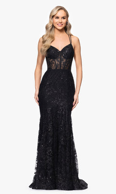 A woman in the Blondie Nites 3960BN Long Glitter Prom Dress, a black fitted gown with thin straps and lace accents, poses against a plain white background.
