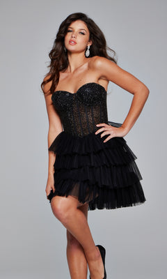 A woman models the Jovani Short Strapless Homecoming Dress 39629, featuring a black, tiered mini skirt and a fitted beaded bodice, as she poses against a plain gray background.