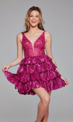 A woman smiles as she poses in the Jovani 39700 Ruffled Short Glitter Hoco Dress, featuring a sleeveless deep V-neck, layered ruffles, and vibrant pink sequins against a plain background.