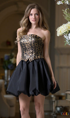 A woman stands indoors wearing the Short Homecoming Dress: Colors Dress 3977 in Black Leopard, featuring a strapless beaded leopard print corset bodice and a black bubble skirt.