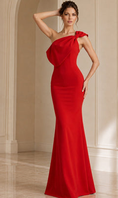 A woman poses in a neutral-toned room, wearing the Jovani 39971—a floor-length, fitted red mermaid formal dress with a single shoulder strap—her hand resting on her head and the other on her hip.