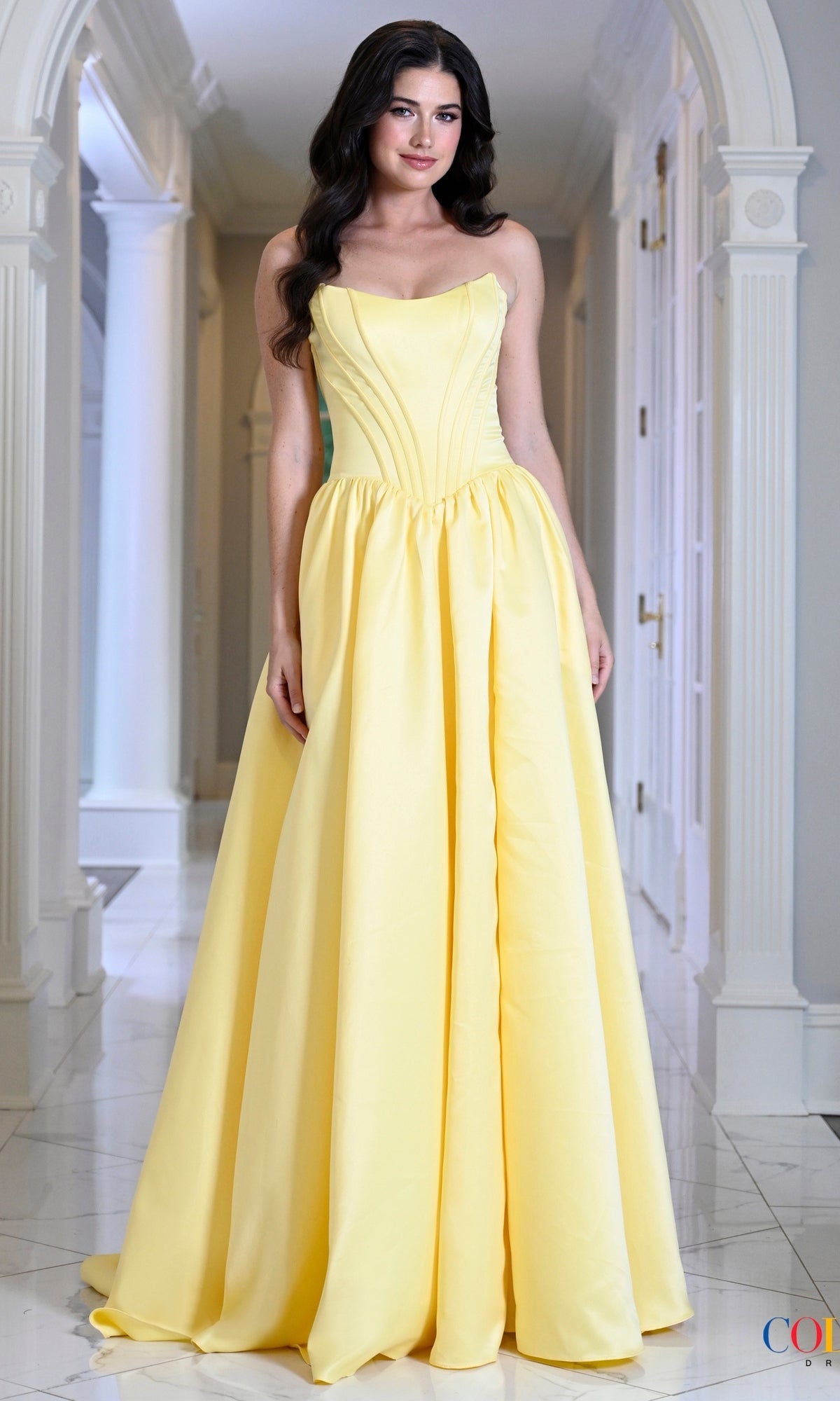 A person wearing a yellow Long Prom Dress: Colors Dress 3997, featuring a floor-length design with a structured, strapless corset bodice.