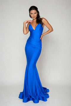 A woman poses against a plain light background in the Ruched Empire-Waist Long Mermaid Prom Dress: 6536H, featuring a bright blue hue and deep V neckline.