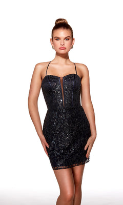 A woman poses against a white background in the Short Beaded Midnight Hoco Dress: Alyce 40002, featuring thin straps, a sheer bodice panel, and black sequin embellishments.
