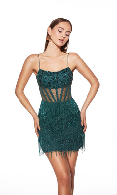 A woman models the Alyce 40022 short homecoming dress: a sleeveless, dark green beaded mini with thin straps, sheer paneling, and a fitted fringe skirt, set against a white background.