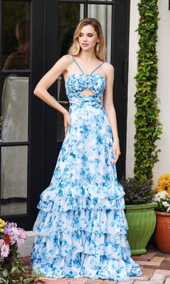 A woman stands outdoors wearing the Ava Presley 40026 Keyhole Floral-Print Prom Dress, featuring blue and white flowers, a waist cutout, and a tiered A-line skirt, next to a green potted plant and flowers.