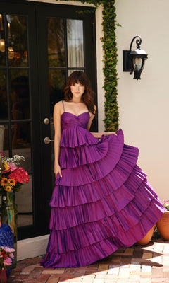 A person stands before glass doors, holding the edge of the Ava Presley 40046 Ruffled Prom Ball Gown with a sweetheart neckline. Nearby, flowers in vases are arranged on the ground.