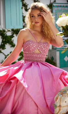 A woman in the Ava Presley 40054 Horsehair-Hem Prom Ball Gown, a bright pink beaded dress, stands outdoors touching her hair with greenery and a tiled wall in the background.